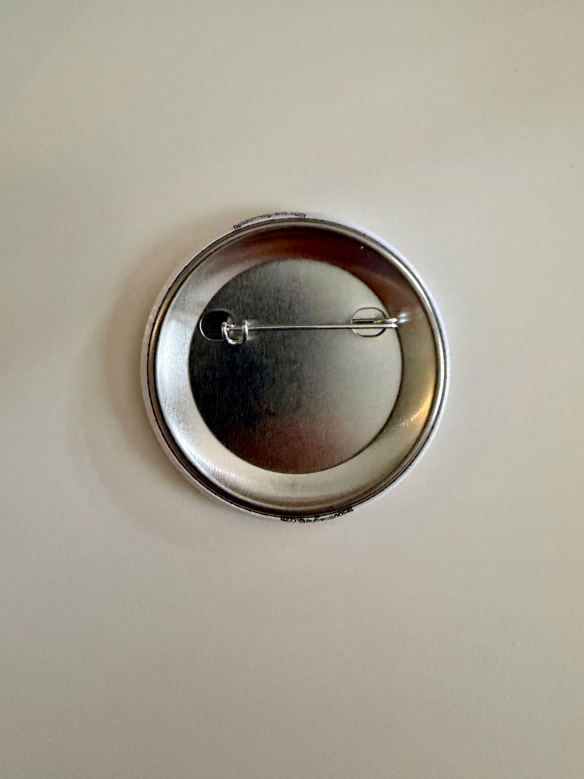 Custom 2.25" round pin worn on red shirt showing lifestyle use – Field of Magnets